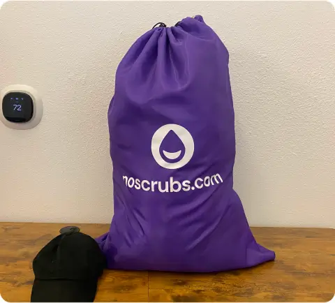 Purple NoScrubs laundry bag filled with clothes